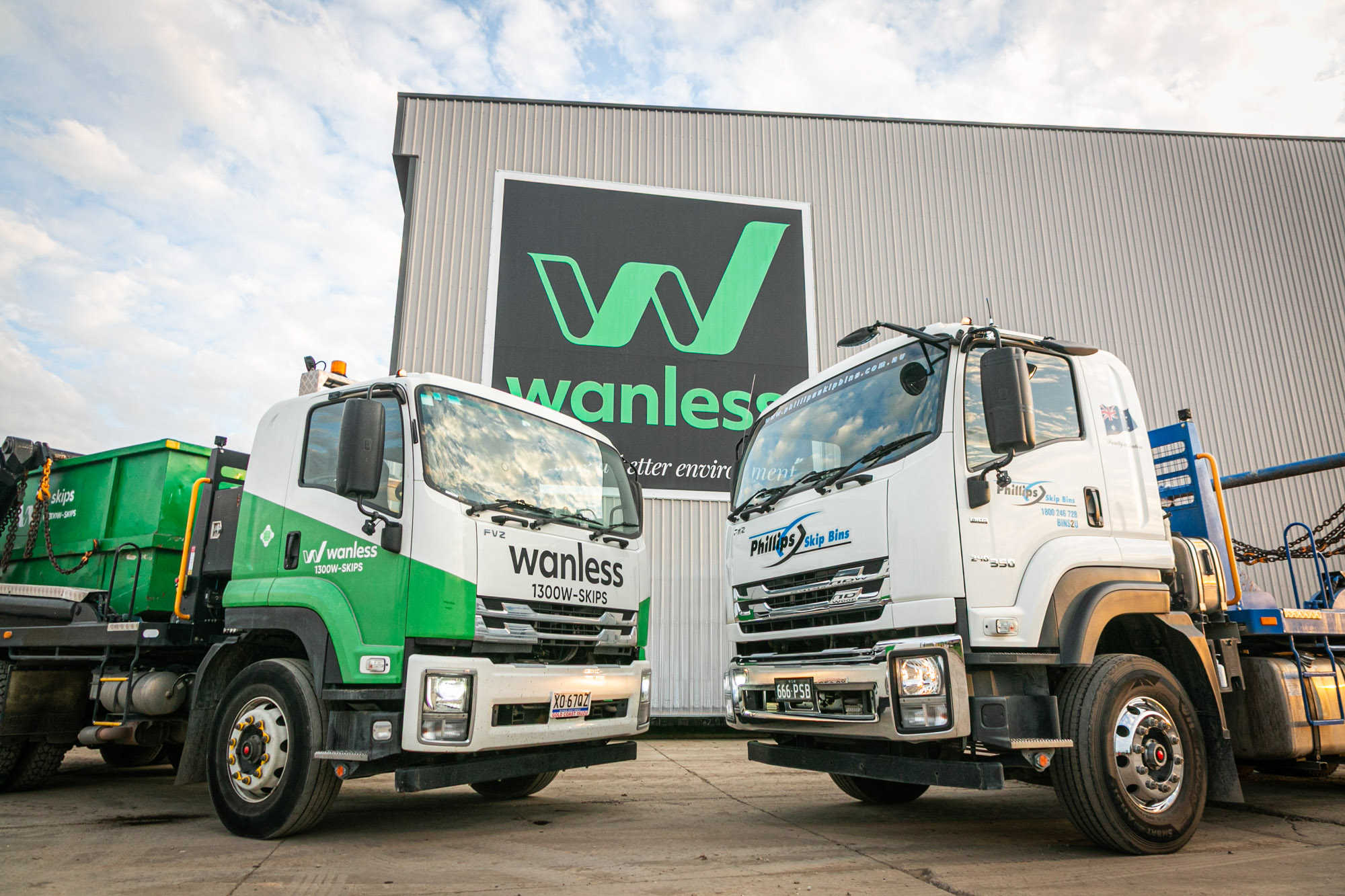 Wanless and phillips skips trucks in front of building | wanless acquisition of phillips skip bins